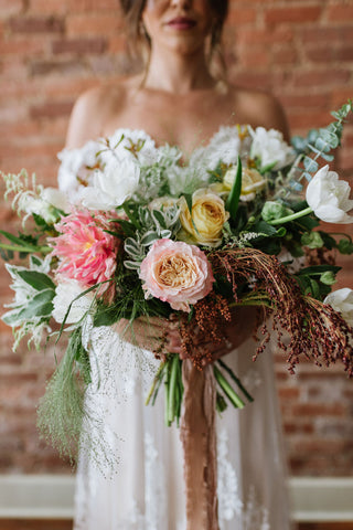 bride holding fall wedding arrangement