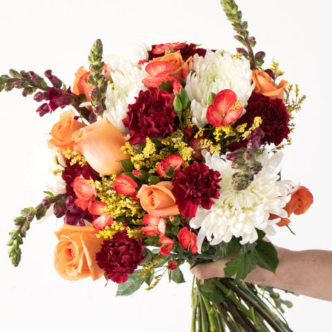 orange, red, and white flower bouquet with roses and carnations