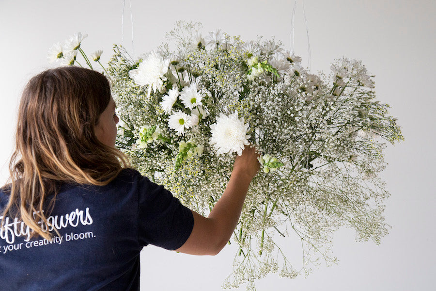 Adding cremons to a hanging floral installation.