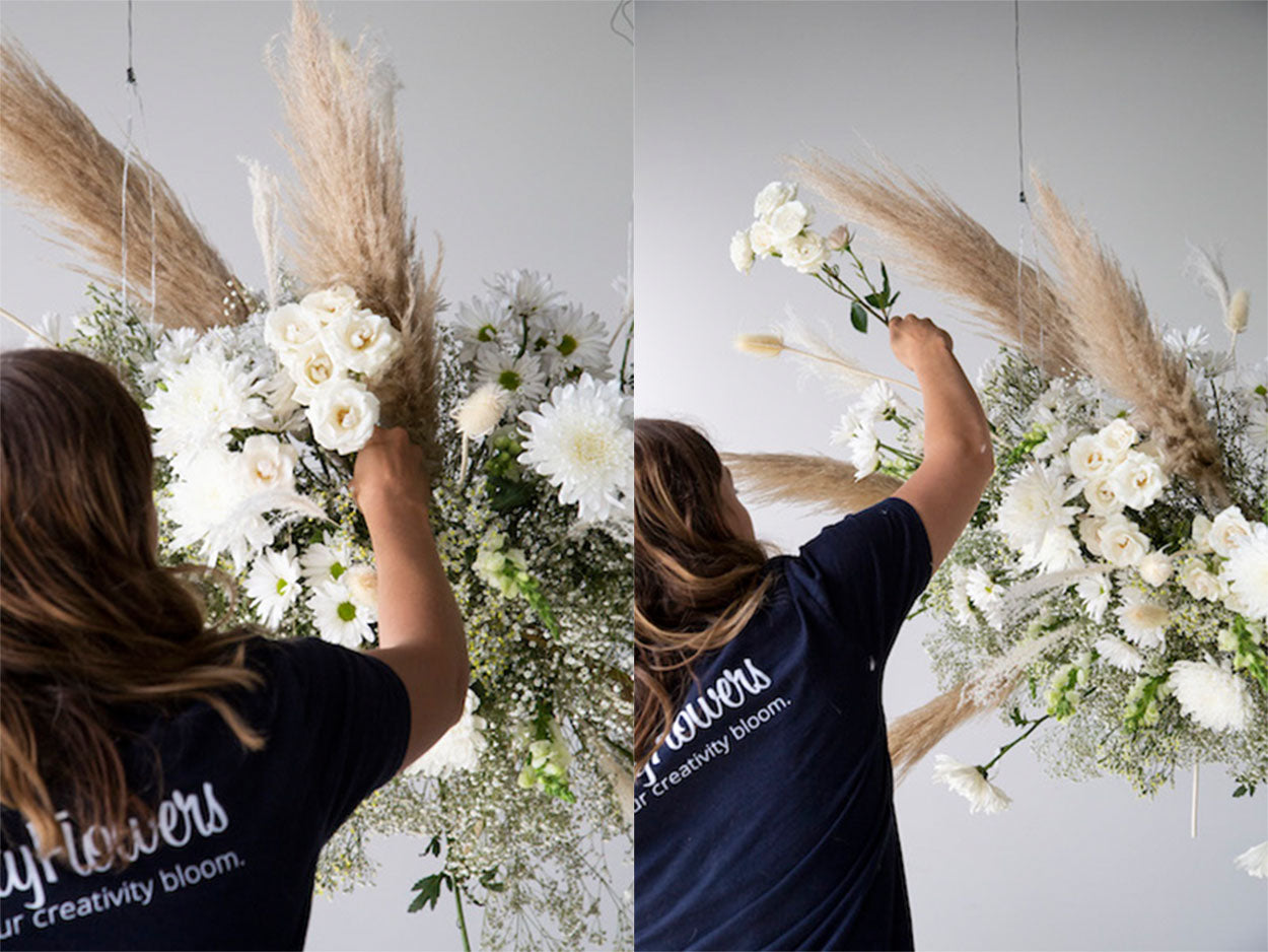 Adding spray roses to a hanging floral installation.