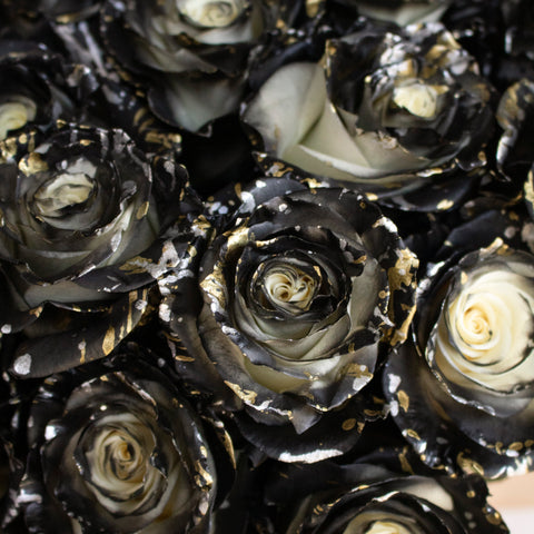 White rose spray painted black with gold accents