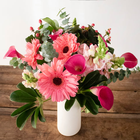 pink flower arrangement with pink gerbera daisies, pink calla lilies, eucalyptus, and more