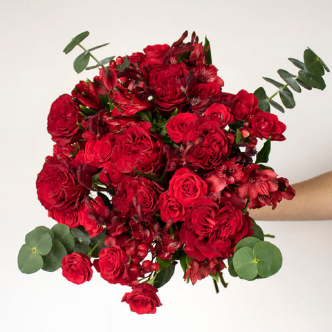 red garden rose bouquet with red roses, hypericum berries, alstroemerias and baby eucalyptus