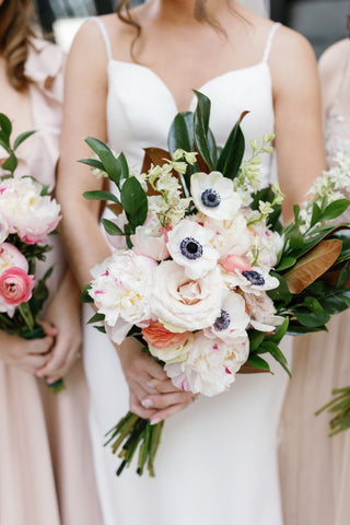 bride holding white and blush bridal bouquet