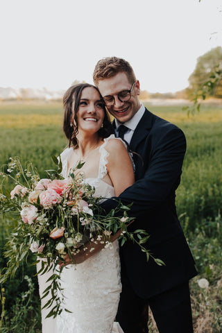 bride and groom with greenery in summer wedding flower bouquet