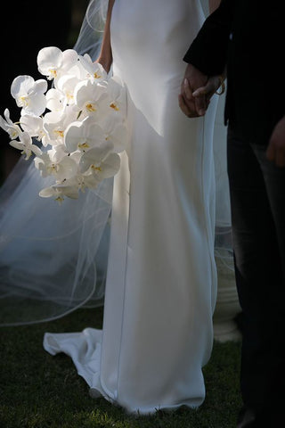 monochromatic white orchid bridal bouquet being held by bride