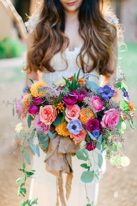 a bright flower bouquet with periwinkle flowers, pink roses, and orange dahlias