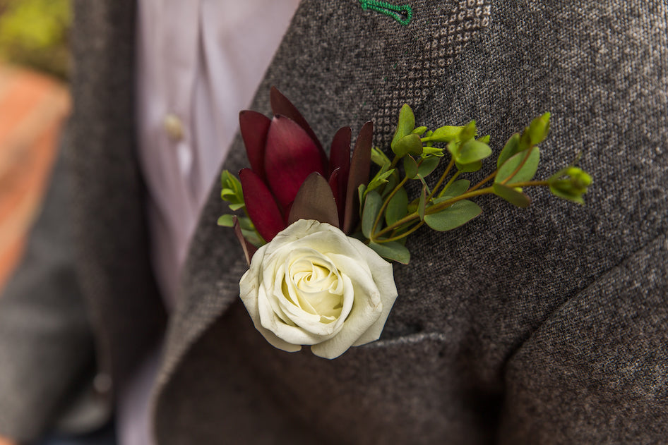 your wedding flower list should include boutonnieres for your groomsmen, officiant, and ushers as well