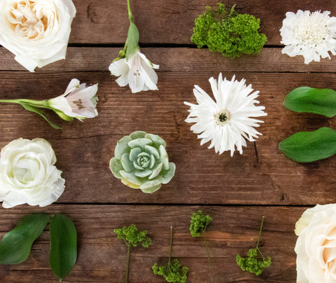 white and green flower flay lay on a wooden table