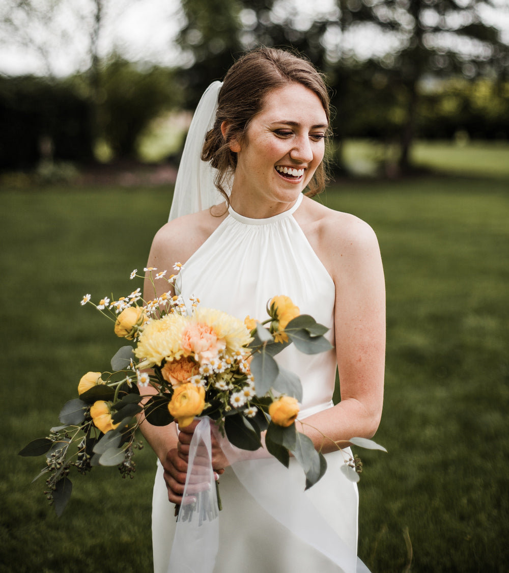 bride holds a unique type of wedding bouquet with yellow flowers 