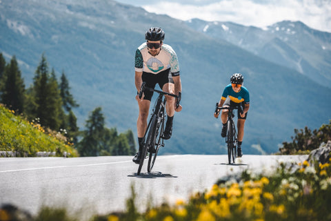 Ein Mann und eine Frau sind mit dem Fahrrad unterwegs. Sie tragen bei de Sportbrille von NAKED Optics, welche mit Wechselgläsern ausgestattet ist. 