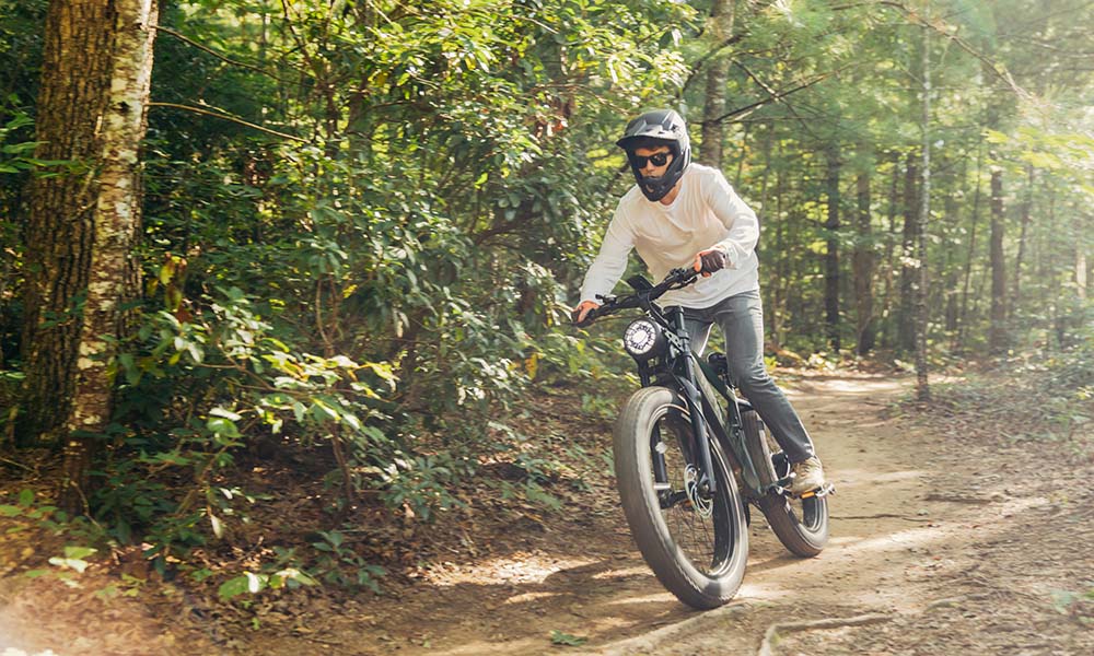 A man is riding a Brawn fat tire e-bike for an off-road adventure