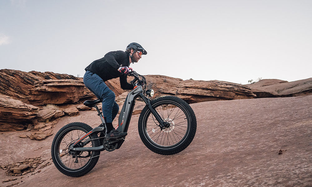 a man riding Hero mid-drive ebike uphill