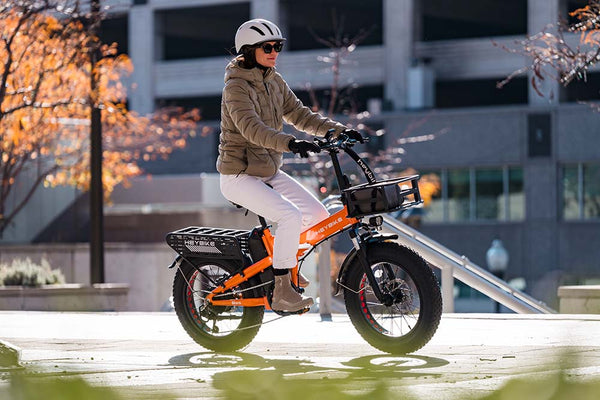 A girl who is wearing a helmet is riding a Mars 2.0 e-bike in the city