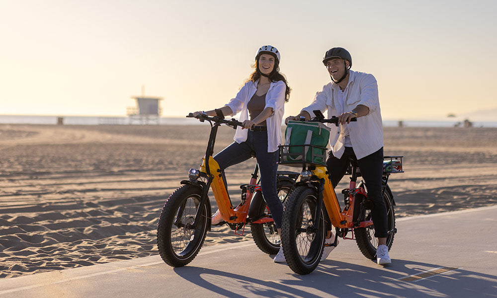 A man and girl are riding Horizon fat tire ebike on beach