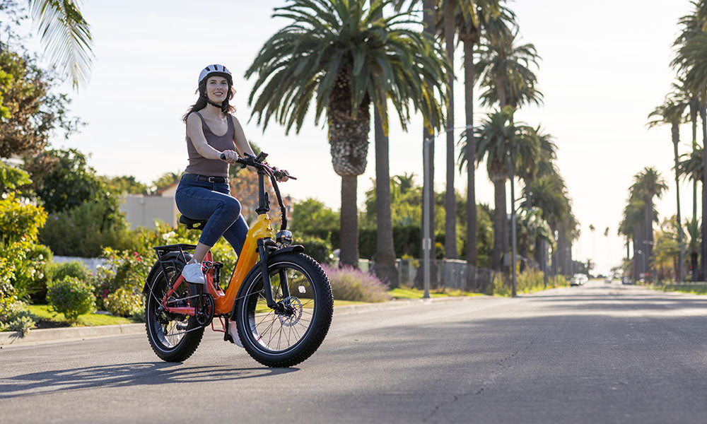 A woman is riding a Horizon step-through e-bike on the road