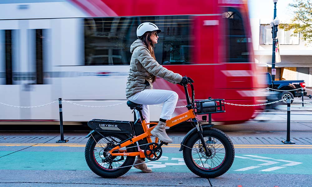 A woman is riding the Mars 2.0 folding e-bike for her work