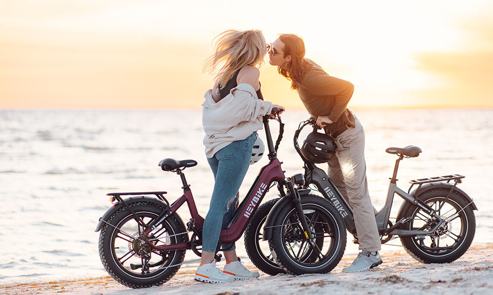 A couple is riding Ranger S fat tire bike on the beach