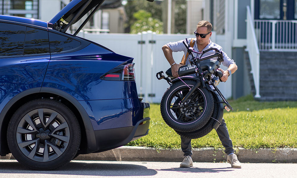 a man is fold up his Ranger S ebike on car trunk