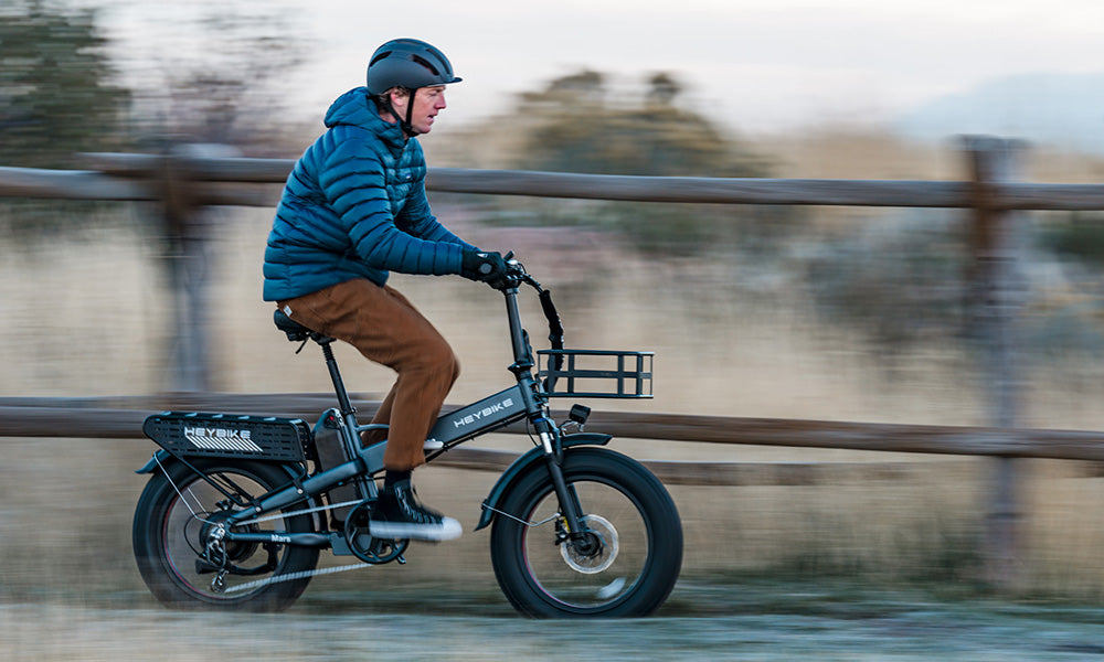 A man is riding a Mars 2.0 folding fat tire e-bike, moving quickly