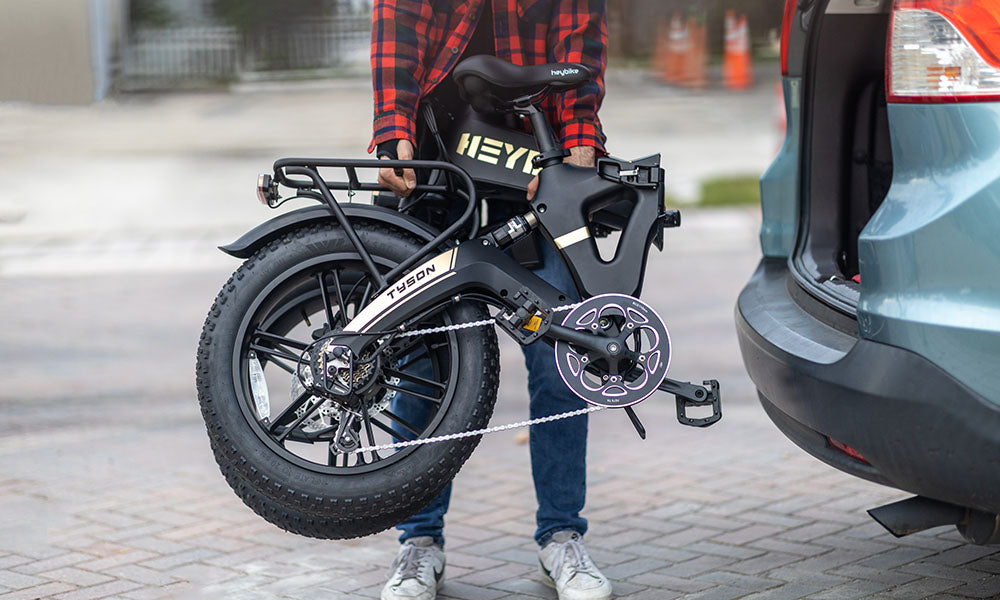 A man is placing Tyson Fold Up eBike on the trunk