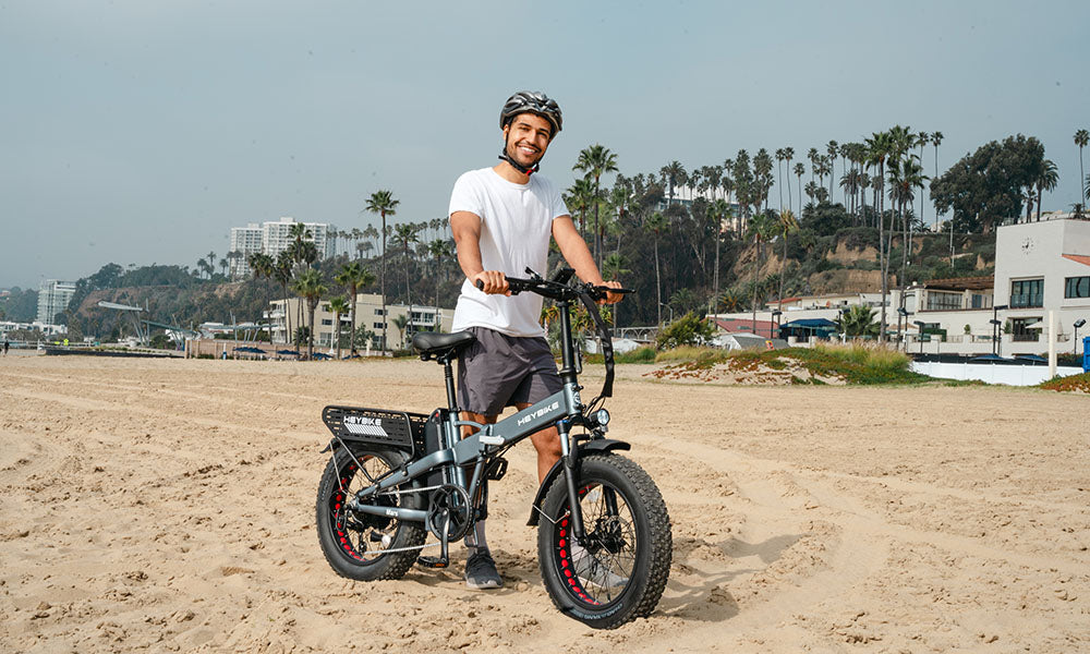 a man is riding Mars 2.0 fat tire on the beach