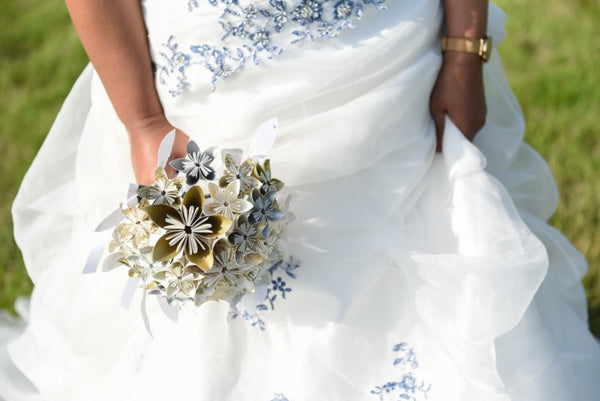 Mariée tenant un bouquet de fleurs en papier origami