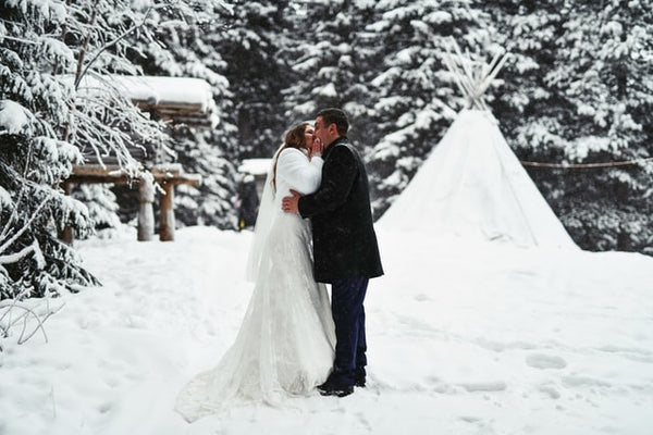 Des mariés en train de s'embrasser dans la neige