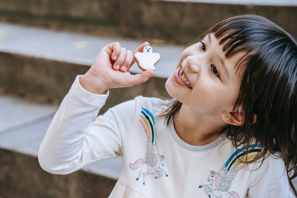 Little girl holding a ghost sugar cookie