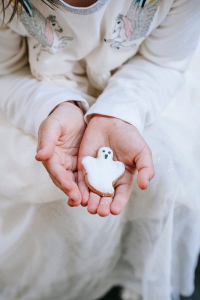Little girl holding a ghost sugar cookie 