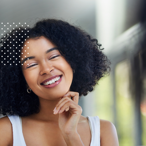 Woman smiling and touching her face