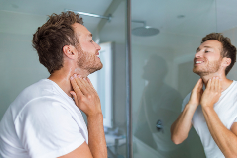 Man itching neck in mirror 