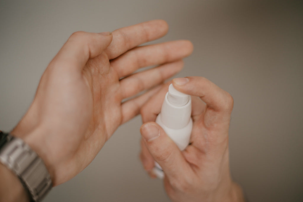 Man putting skincare product into hand 