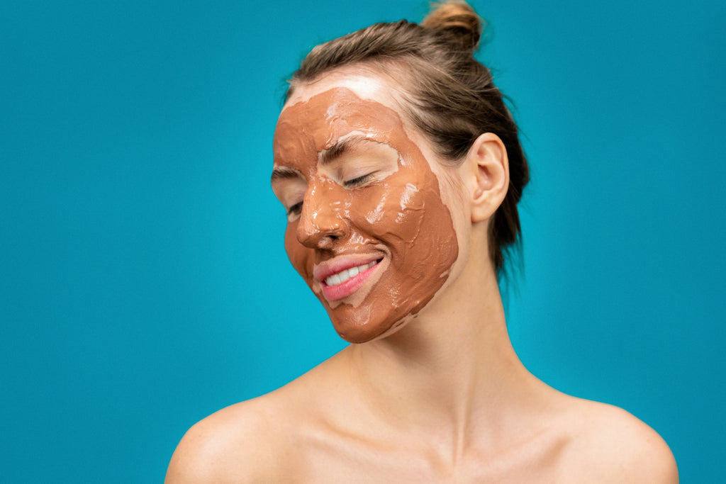 woman smiling with skincare face mask on