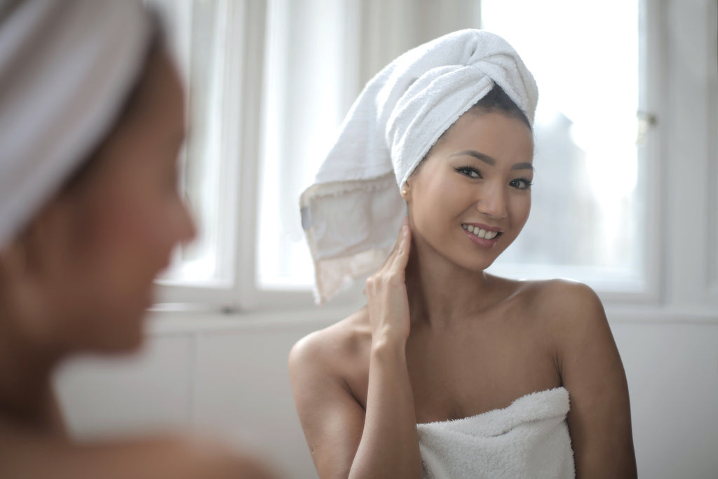 woman looking in mirror with clear sensitive skin 
