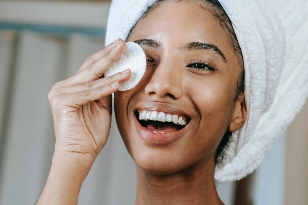 woman using skincare product with cotton pad