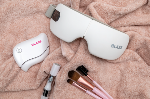 Smart Eye Massager, Lip Plumper and Gua Sha with makeup brushes on a towel 