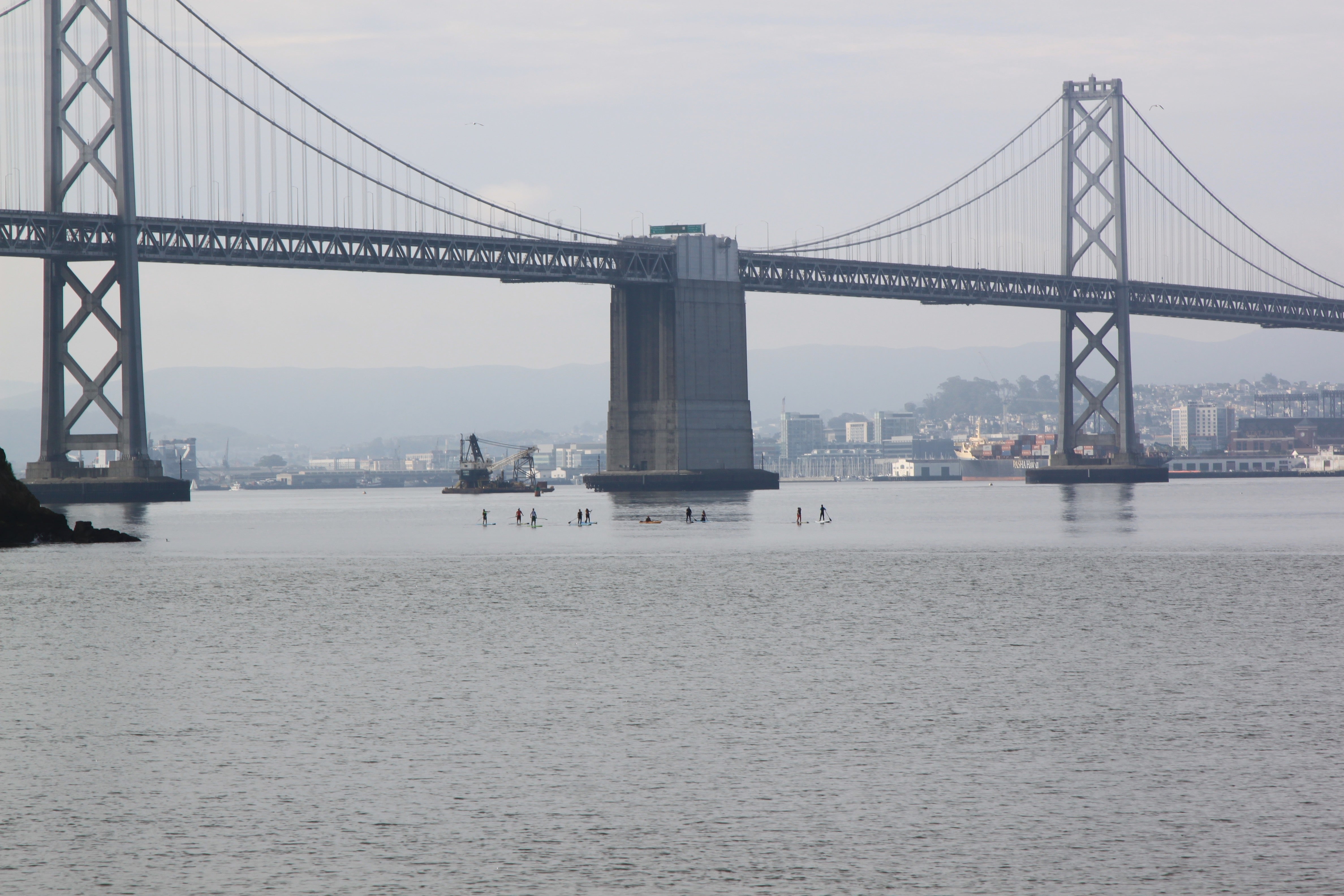 image of SUP paddle boarders under the San Francisco Bay Bridge