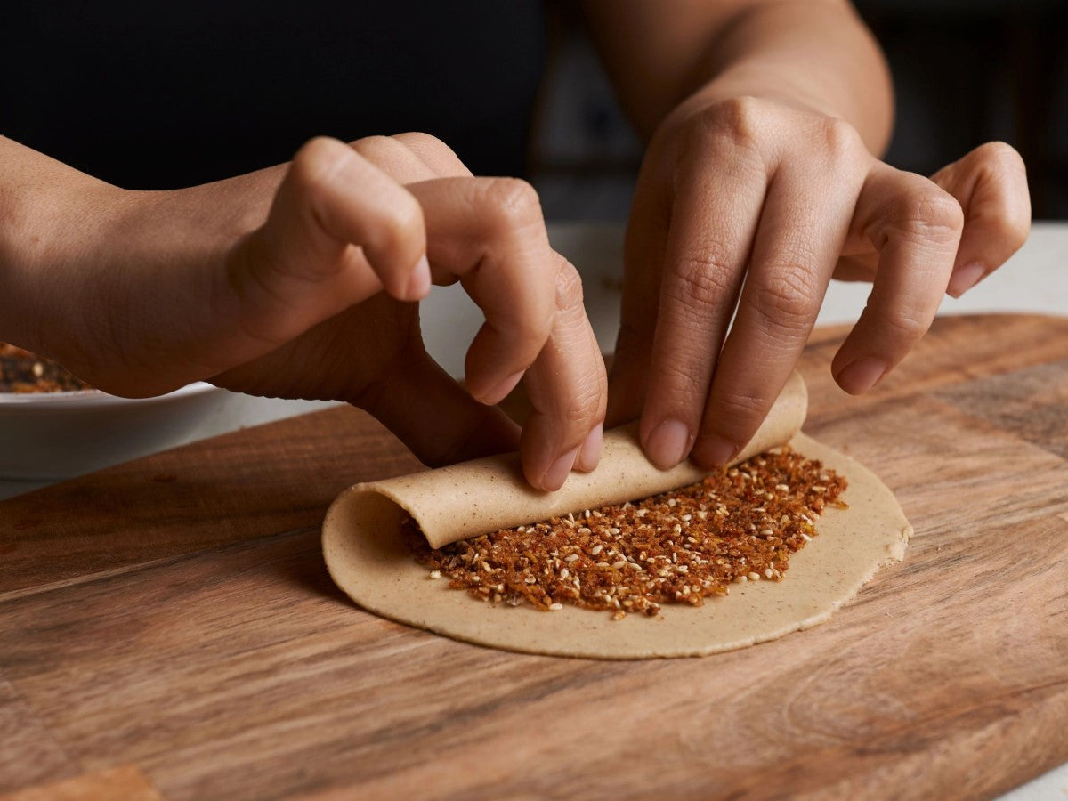 Rolling sesame seeds into roti