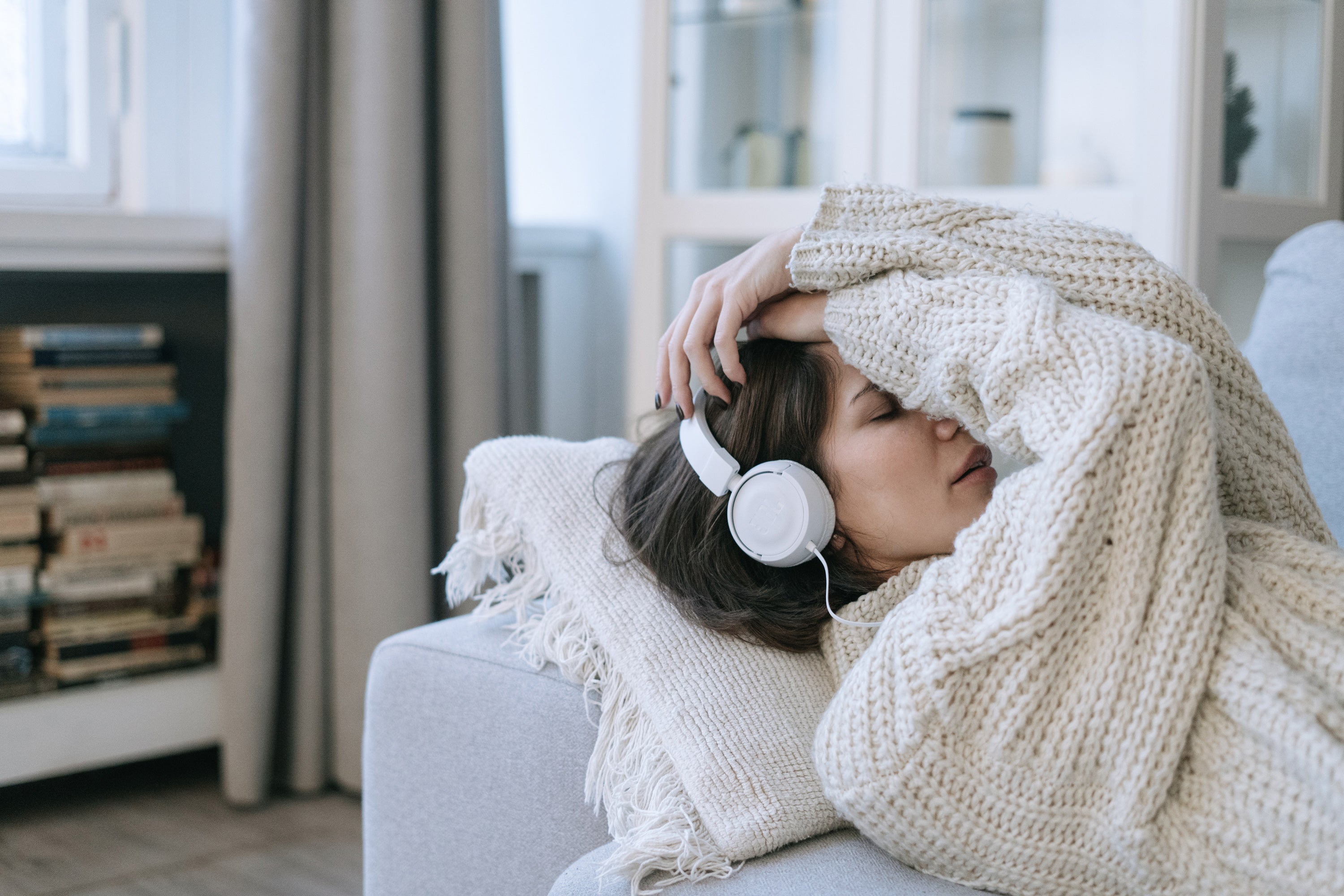 femme allongee dans canape avec casque musique