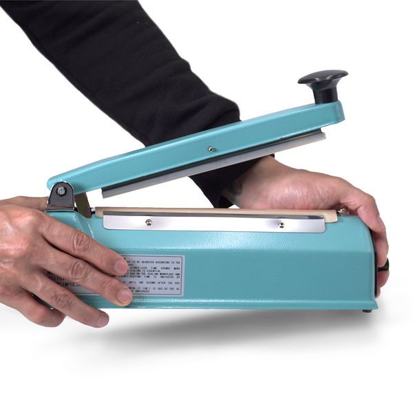 small business owner placing a manual impulse bag sealing machine on a table surface to begin sealing bags with product inside