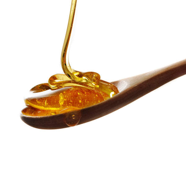 high viscosity liquid that looks like honey being poured onto a spoon