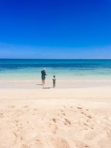 Dad and son on a beautiful beach about to go snorkelling