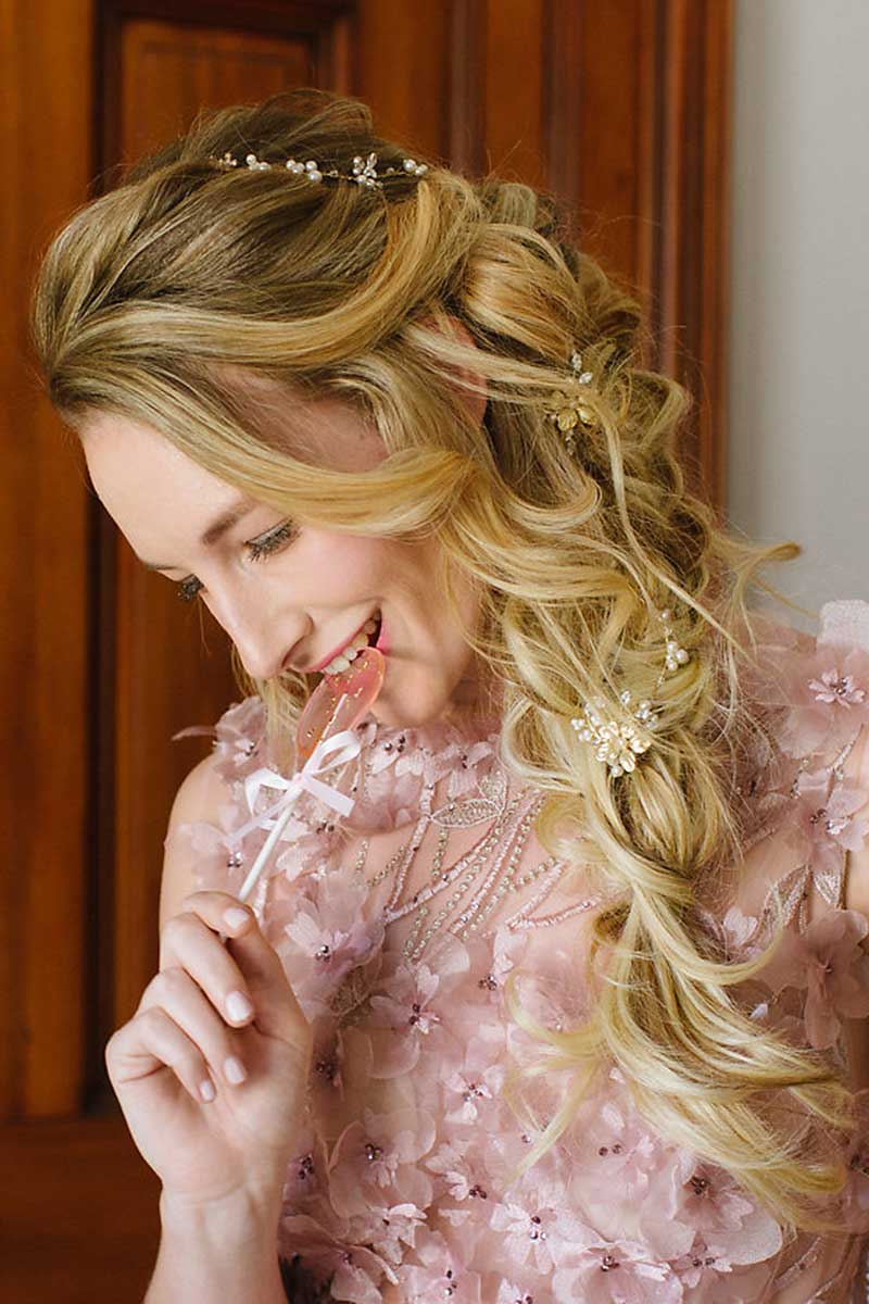 Profile of woman holding lollipop wearing Marisol hairvine and hairpins in side braid