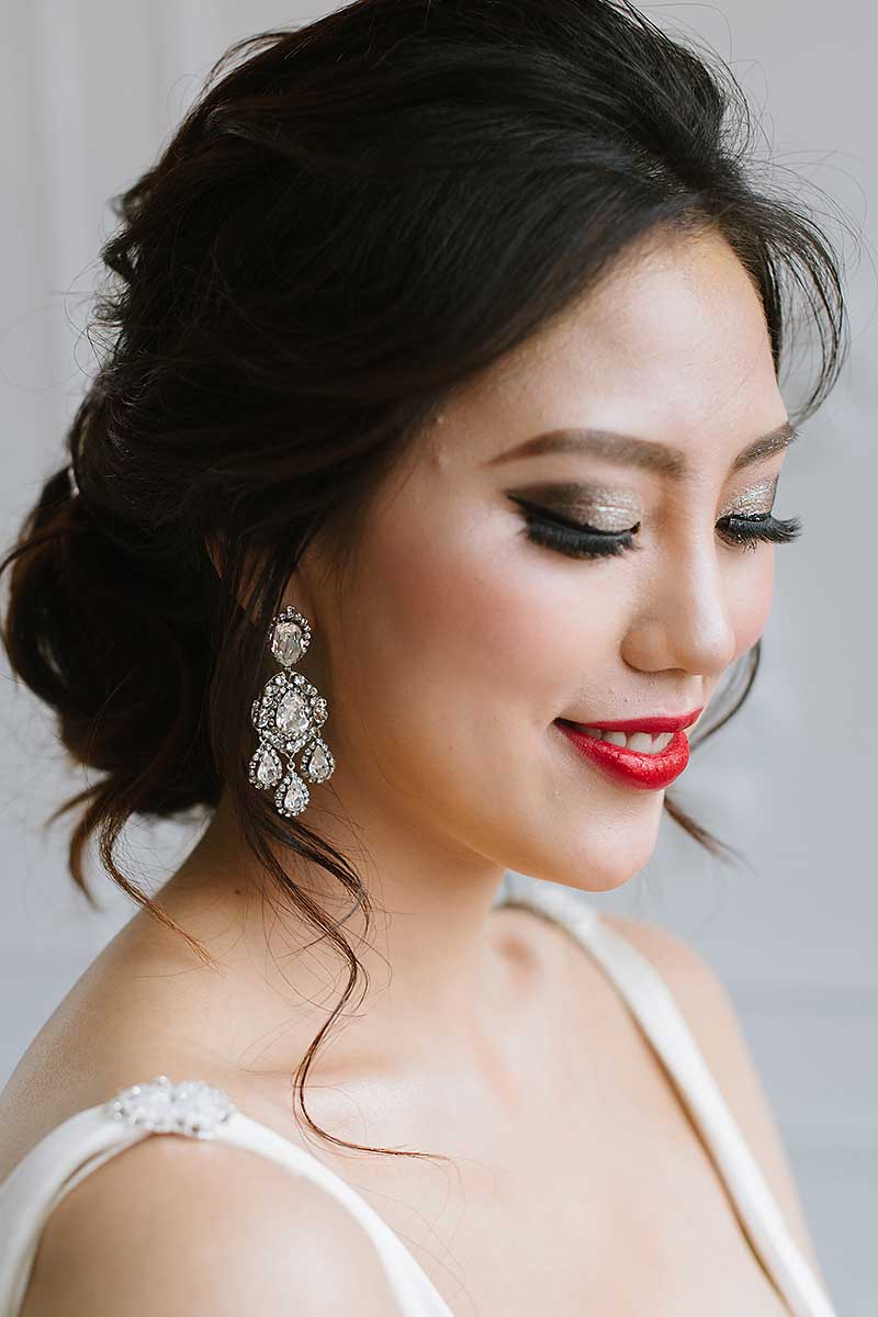 smiling glamorous bride wearing chandelier earrings 
