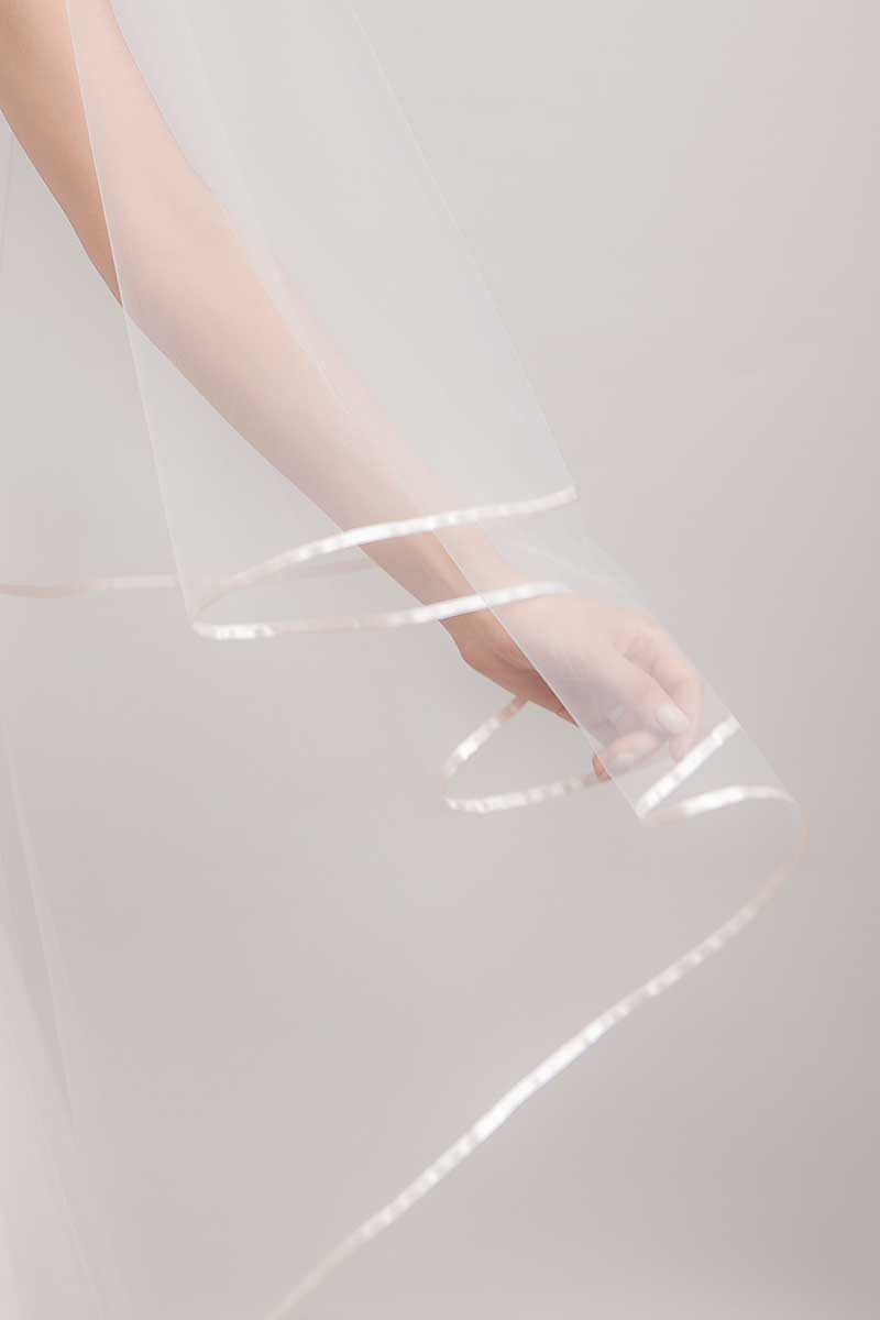 Bride's arm and closeup edge detail of Miranda cathedral veil