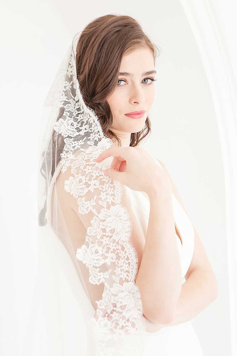 Profile of bride wearing Chantilly lace mantilla veil Peyton by Laura Jayne