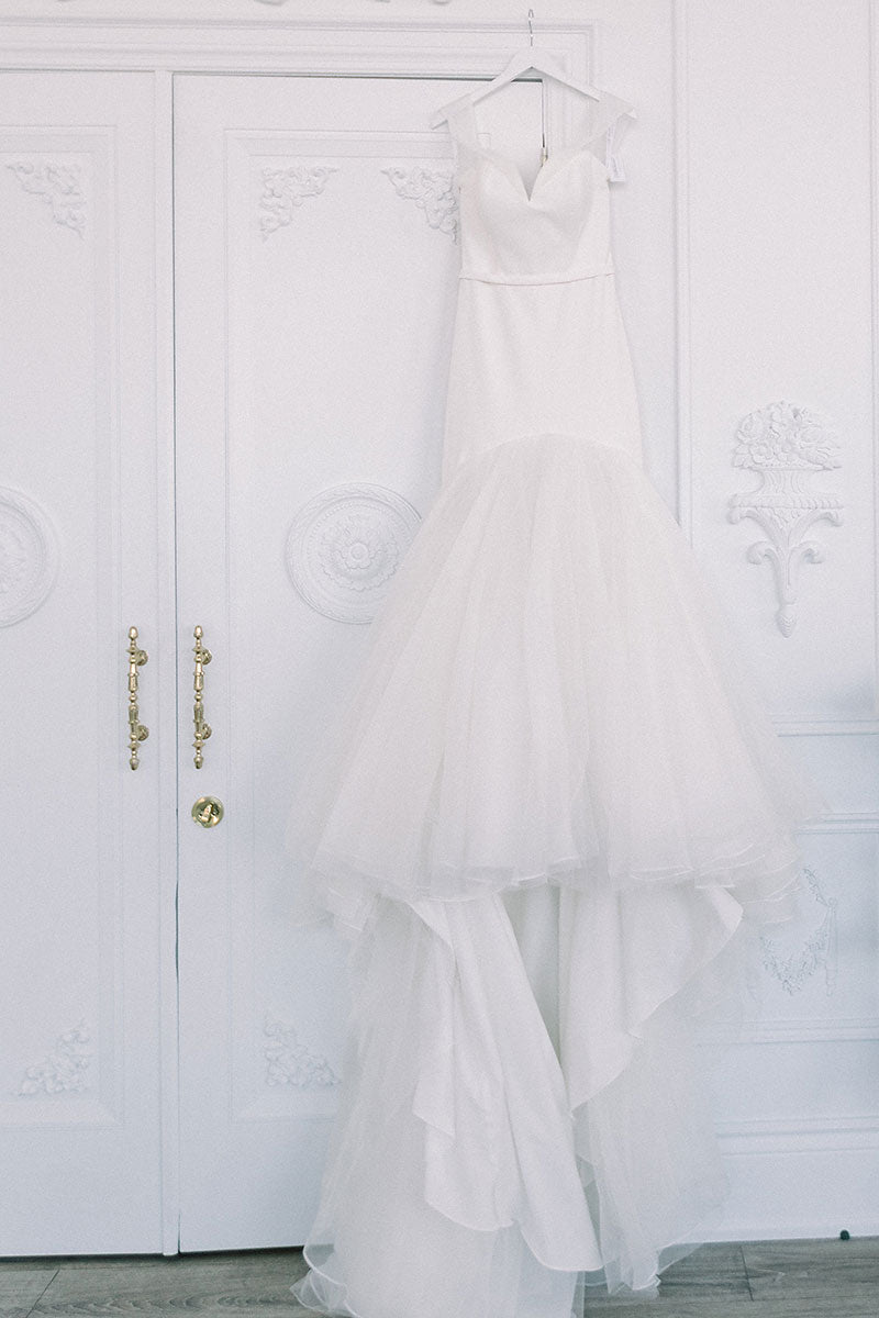 wedding dress hanging on door 