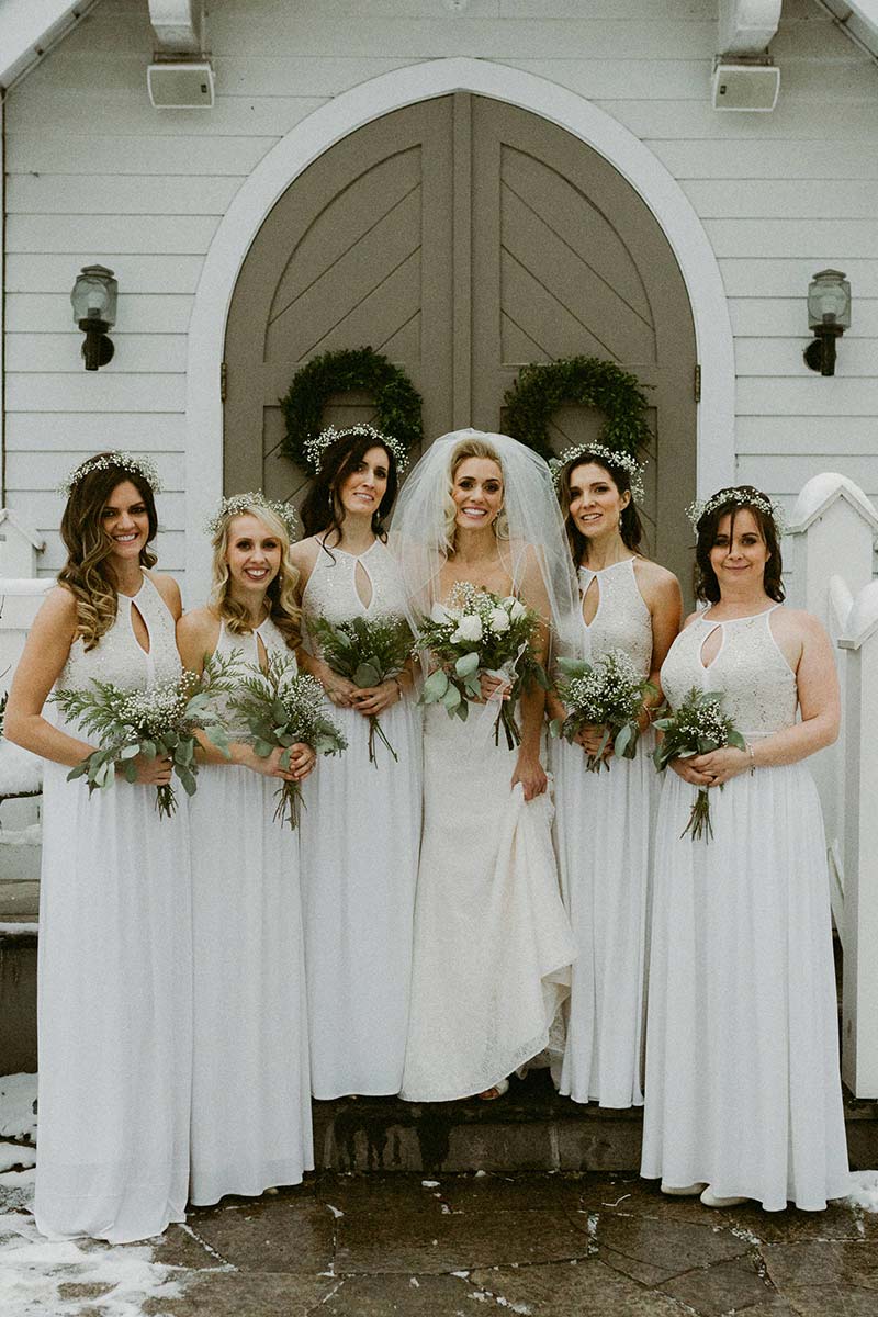 happy bride with bridesmaids holding flower bouquets 