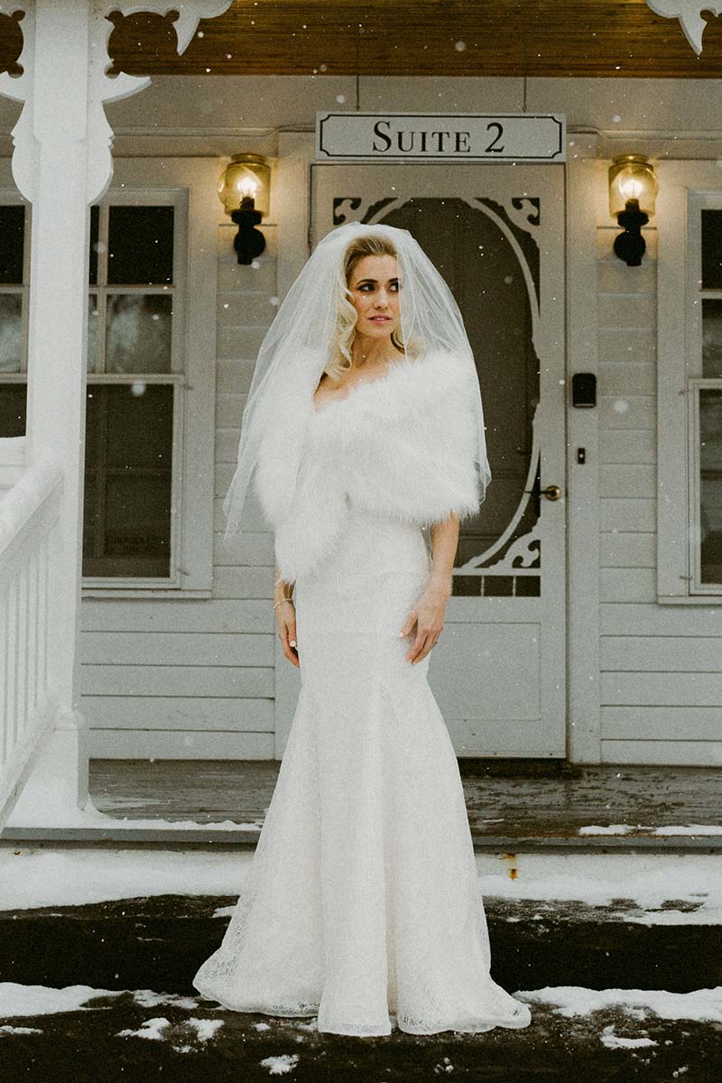 beautiful bride wearing veil and feathers at a winter wedding 